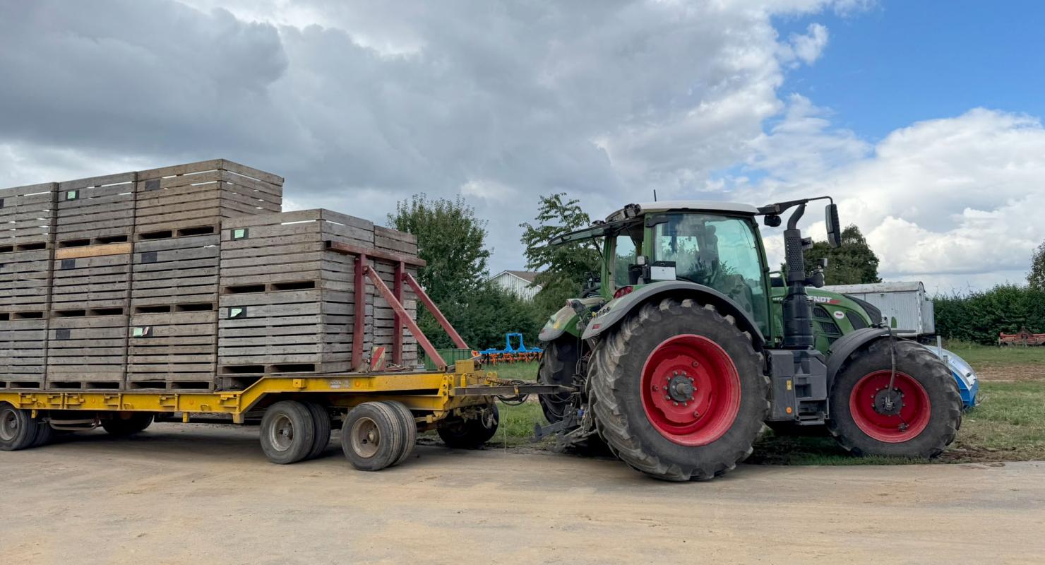 Traktor mit Anhänger voller Großkisten